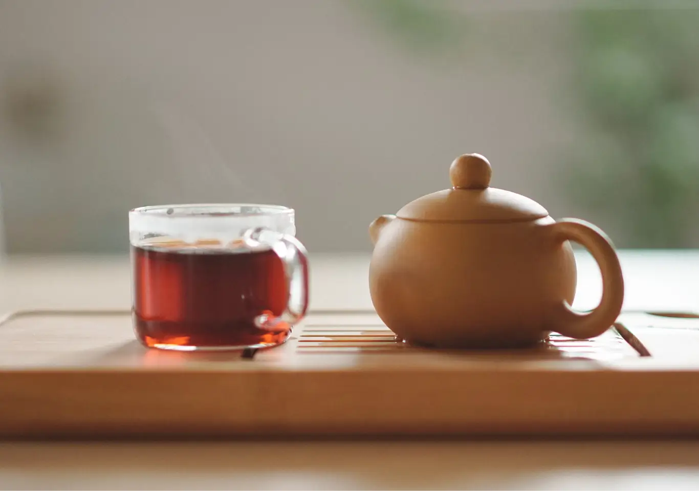 du thé et une theière marron en argile sur une table