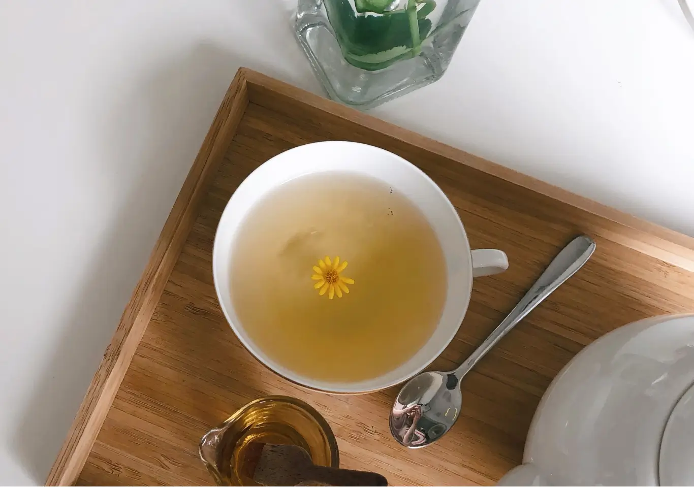 du thé dans une tasse blanche avec une fleur au milieu de la tasse
